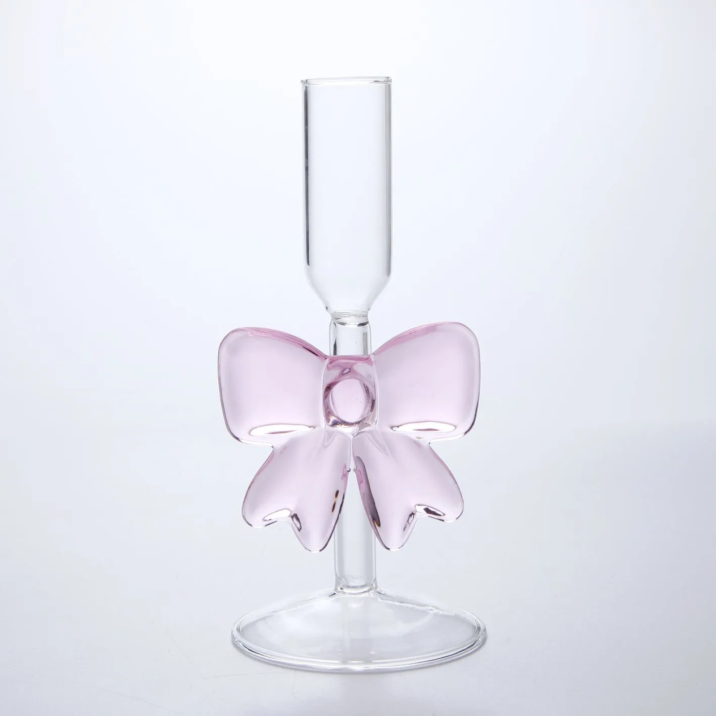 Set of three clear borosilicate glass candlesticks with large bow decorations on a table