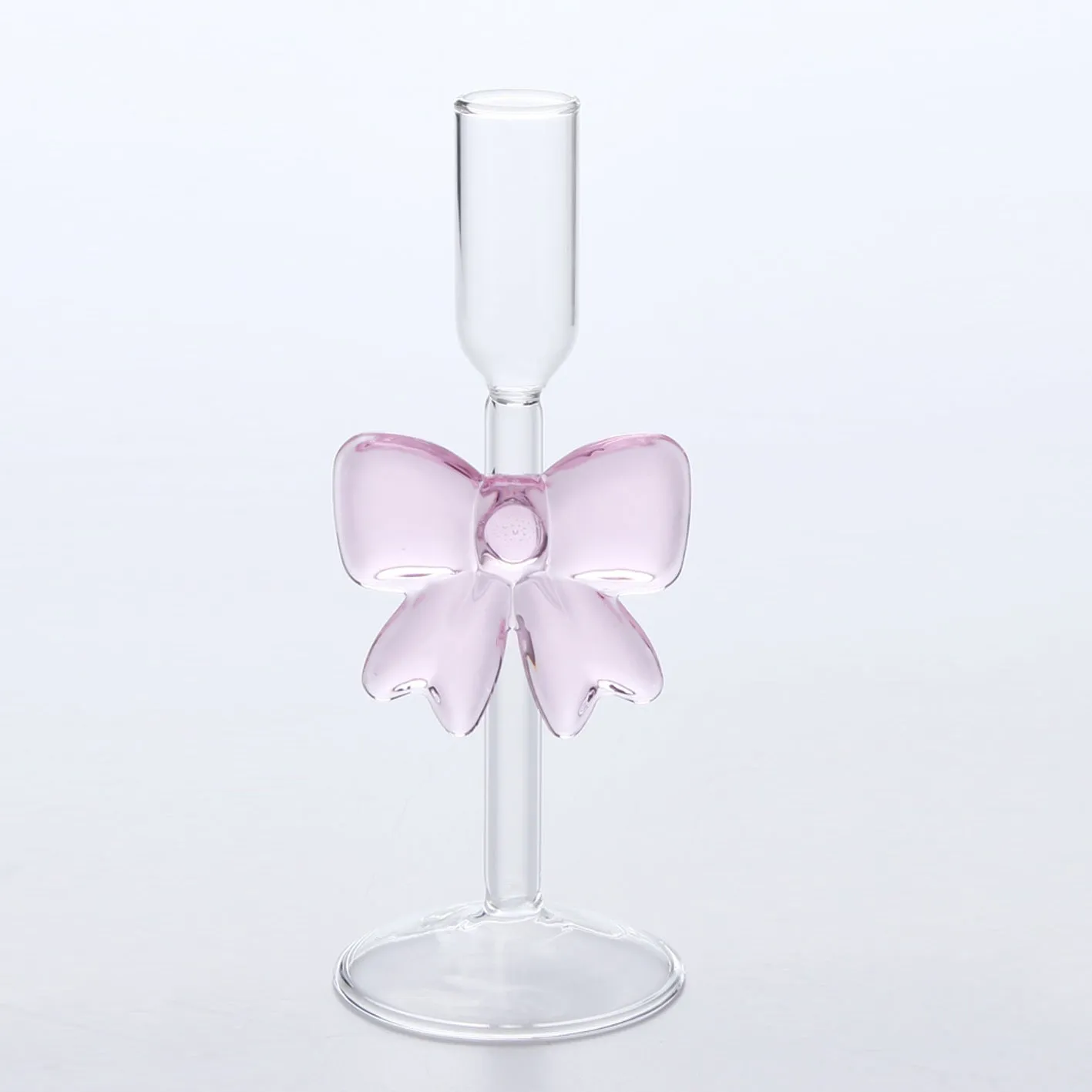 Set of three clear borosilicate glass candlesticks with large bow decorations on a table