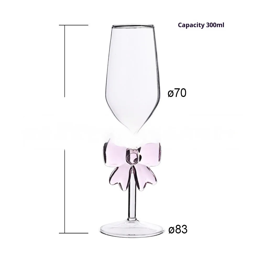 Set of three clear borosilicate glass candlesticks with large bow decorations on a table