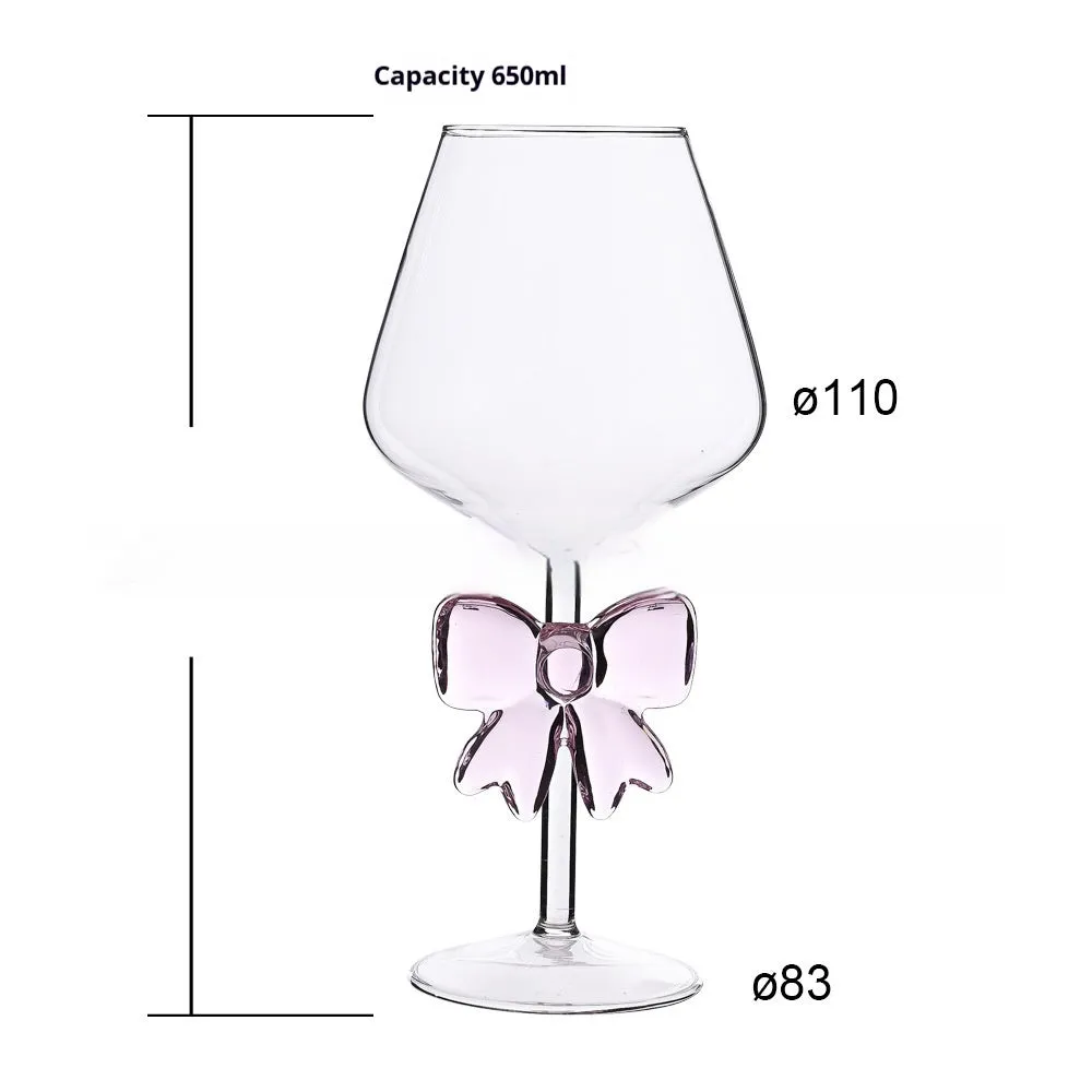 Set of three clear borosilicate glass candlesticks with large bow decorations on a table