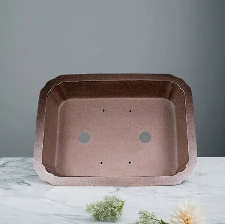 Antique rectangular purple clay flowerpot on a wooden surface with green boxwood plant inside