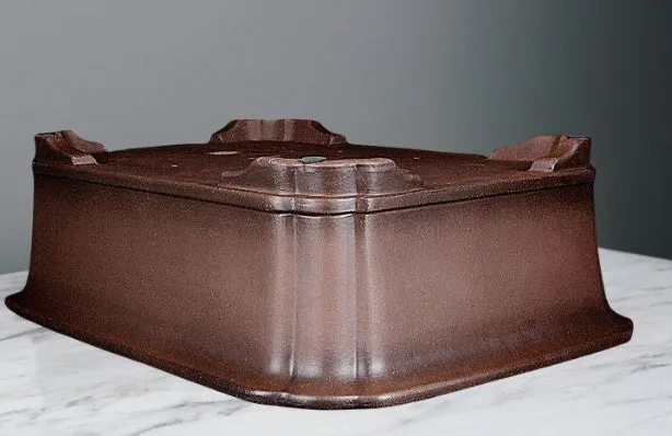 Antique rectangular purple clay flowerpot on a wooden surface with green boxwood plant inside