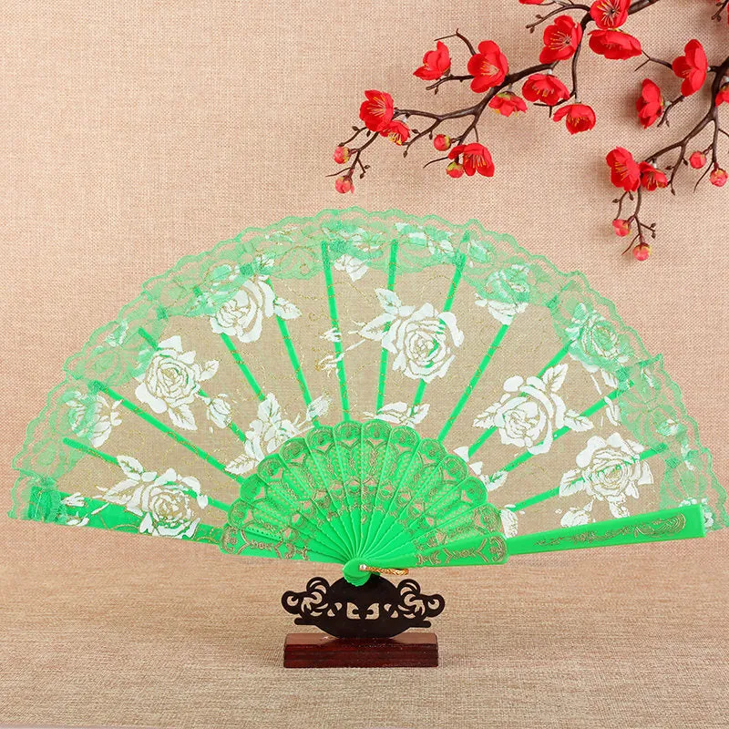 Plastic rose lace folding fan in red with tassel on white background