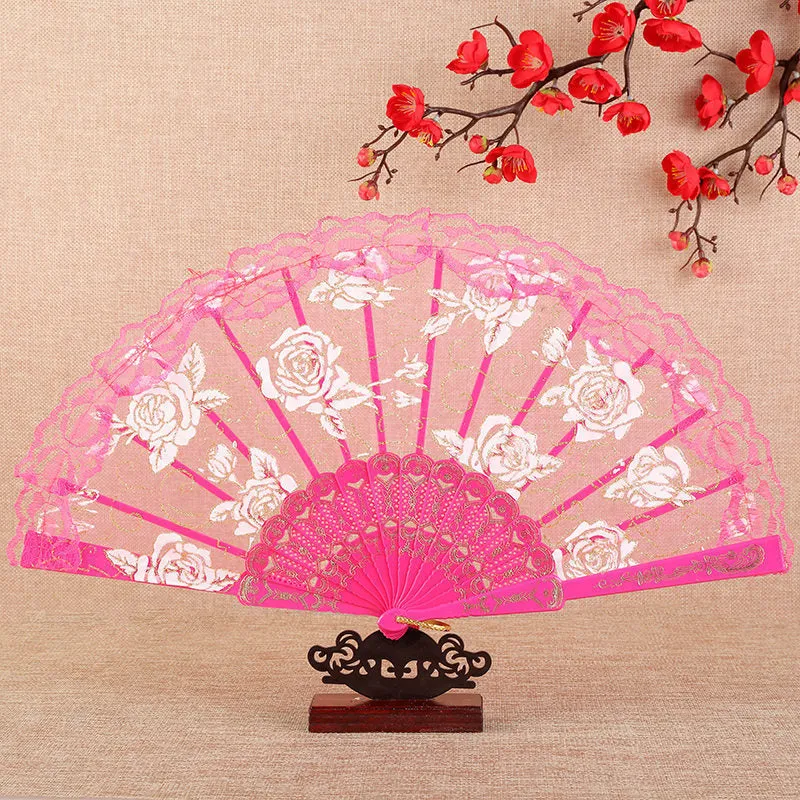 Plastic rose lace folding fan in red with tassel on white background