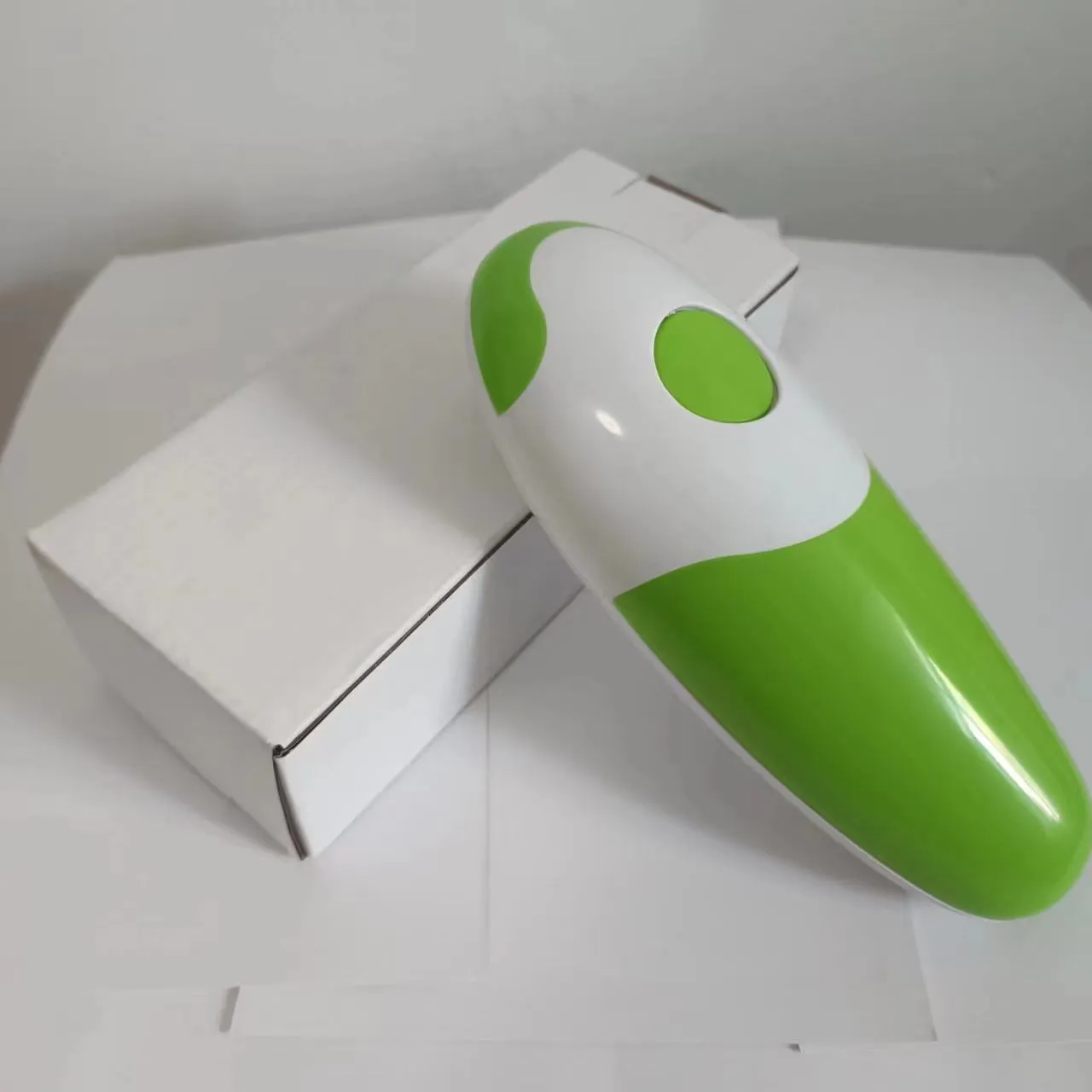 Electric can opener in light green plastic with iron box mechanism, 16x6.5x4.8cm, on kitchen countertop
