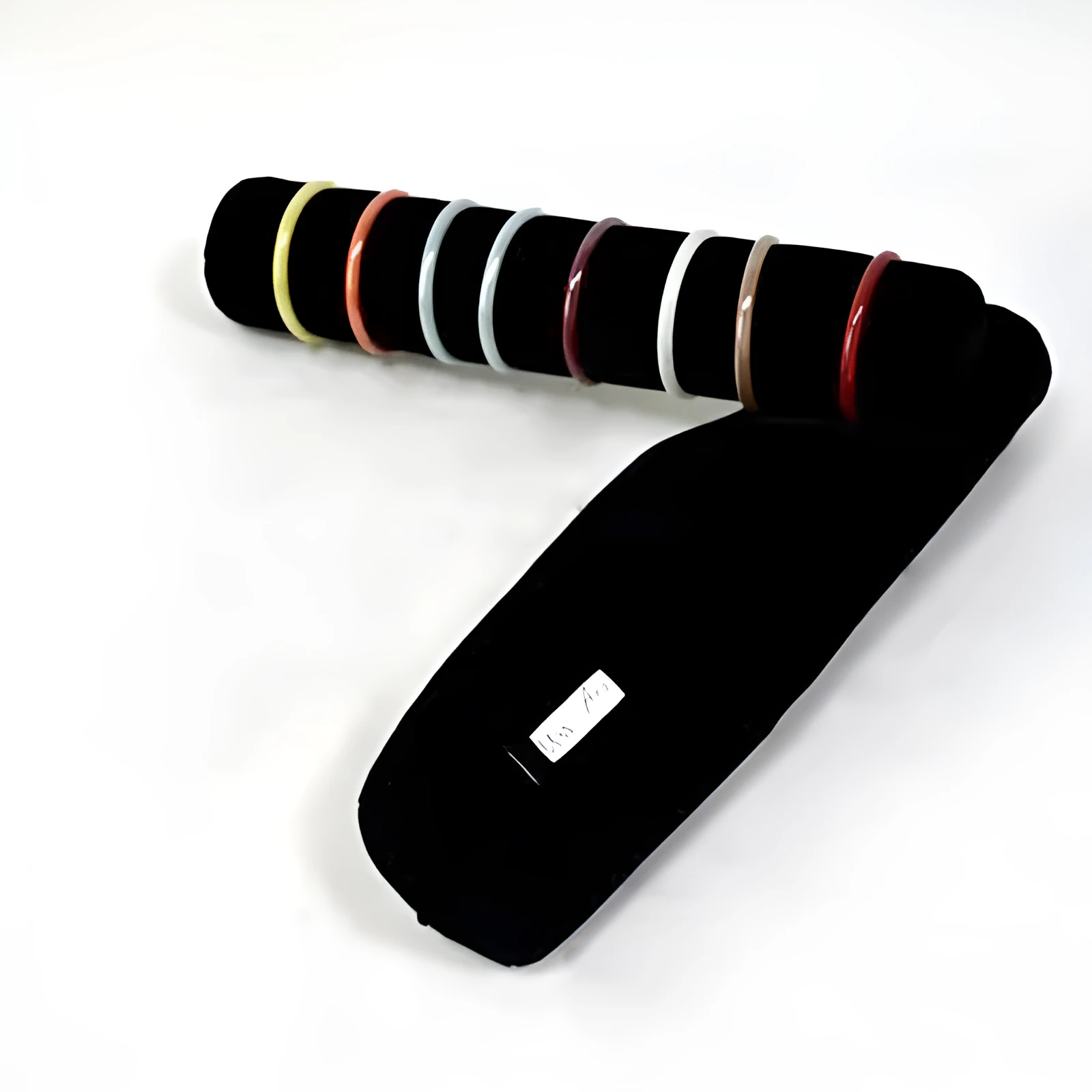 Portable bracelet watch storage bag in black leather with black bracelet stick on a flat surface