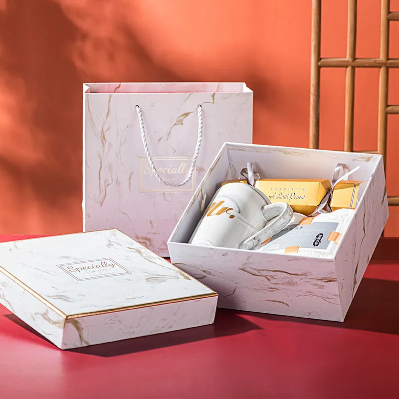 Light luxury ceramic cup gift box set with pink mug, candy, and towel on display