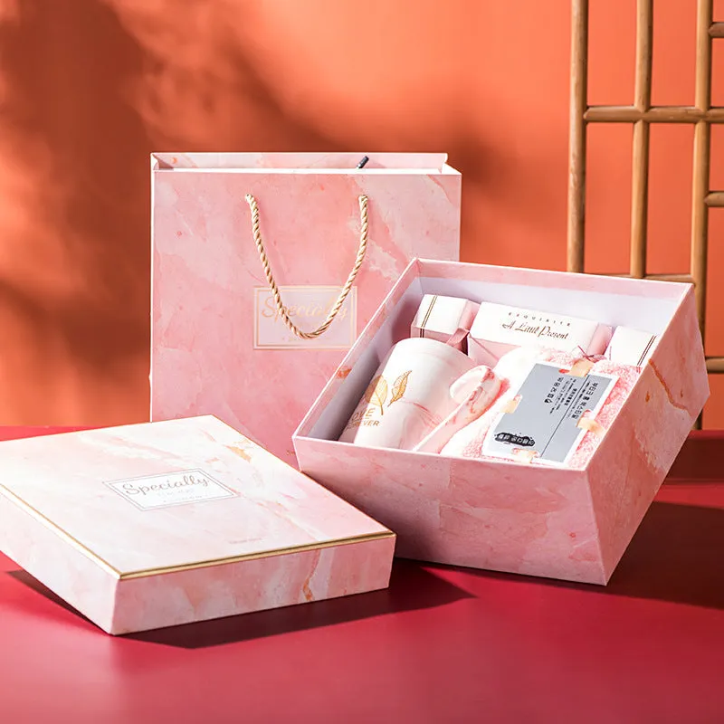 Light luxury ceramic cup gift box set with pink mug, candy, and towel on display