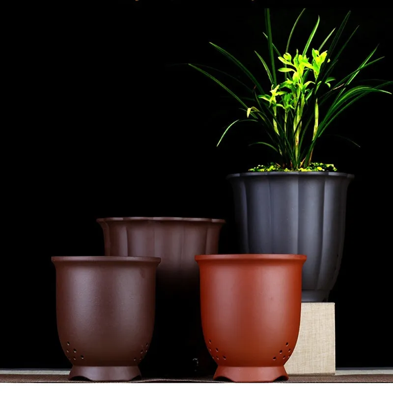 Round ceramic desktop bonsai basin in black with four drainage holes for small plants