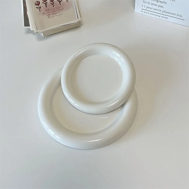 White ceramic plate with cartoon bear doodle design, shown next to round toot design plate, both microwave safe.