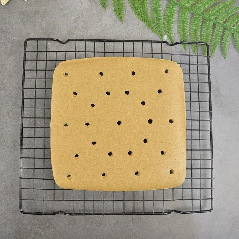 Stack of oiled paper square baking sheets with holes for air fryer use natural colour 20cm
