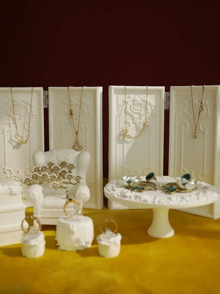 White plaster retro jewellery display stand with three layers, neutral background for necklace display