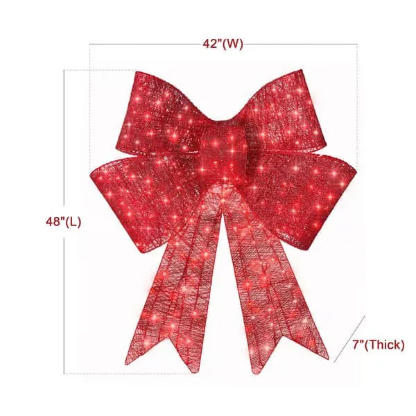 Red satin light up Christmas bowknot on a tree branch with warm glow