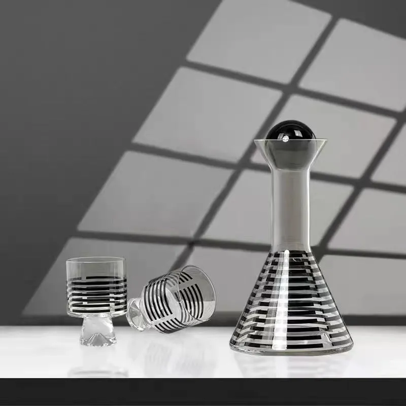 Modern black striped glass cold water bottle 1000ml with two cups on a light surface