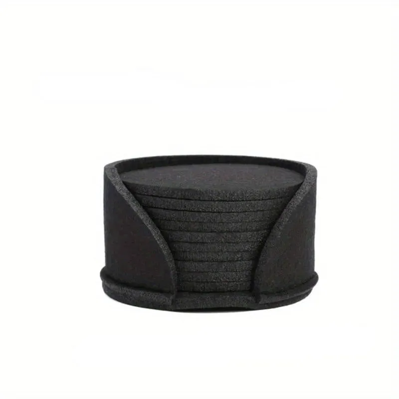 10 round felt coasters in black, brown, dark gray, and light gray arranged on a dining table