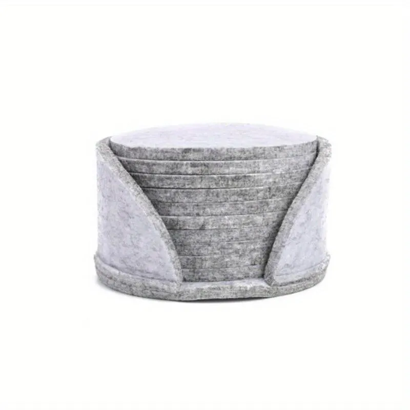 10 round felt coasters in black, brown, dark gray, and light gray arranged on a dining table