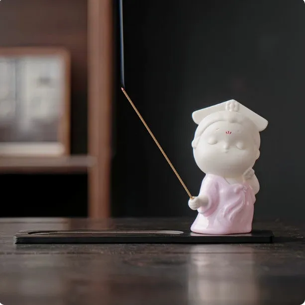 Cute ceramic female court attendant figurine incense burner decoration on a desk.