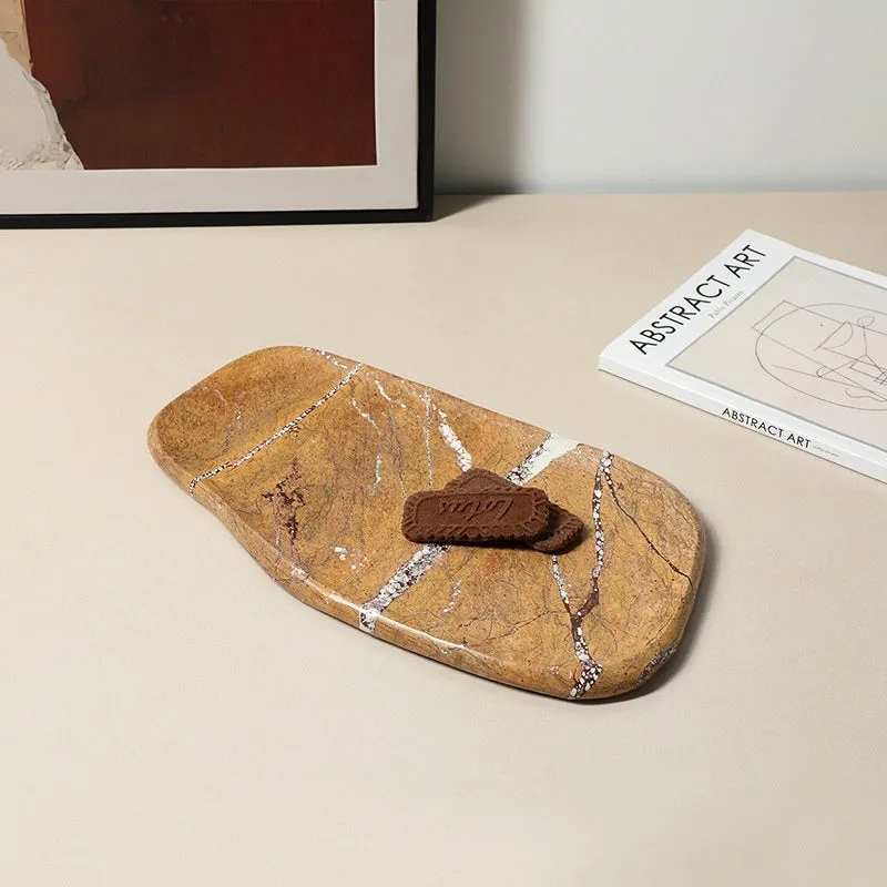 Irregular natural marble tray in coffee colour on a wooden coffee table with decorative objects