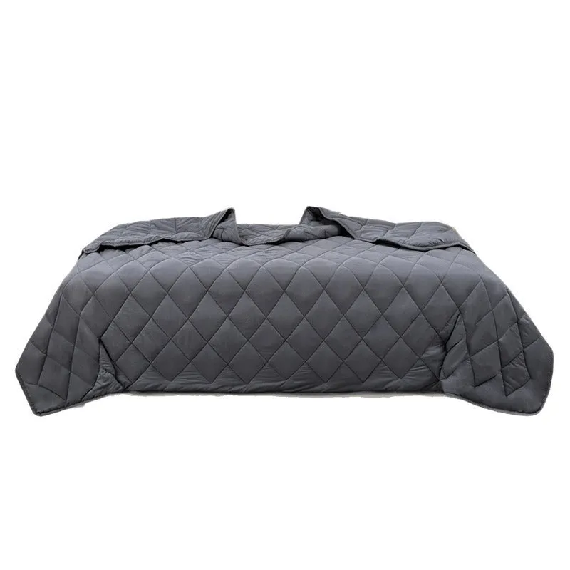 Polyester gravity blanket in solid light grey on bed, 152x203cm size, 12 lb weight option