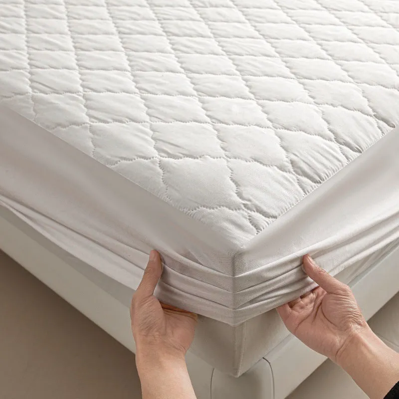 Diamond quilted black waterproof mattress protector fitted sheet and pillowcases set on a bed