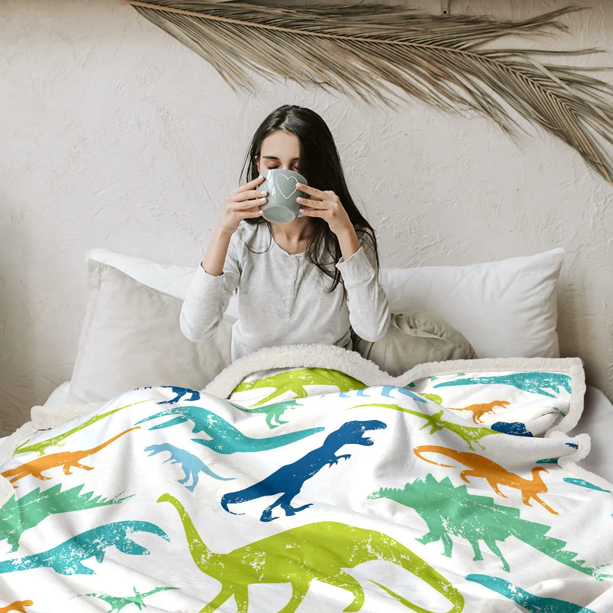 Dinosaur themed lamb wool blanket in white on a sofa, measuring 130x150cm or 150x200cm