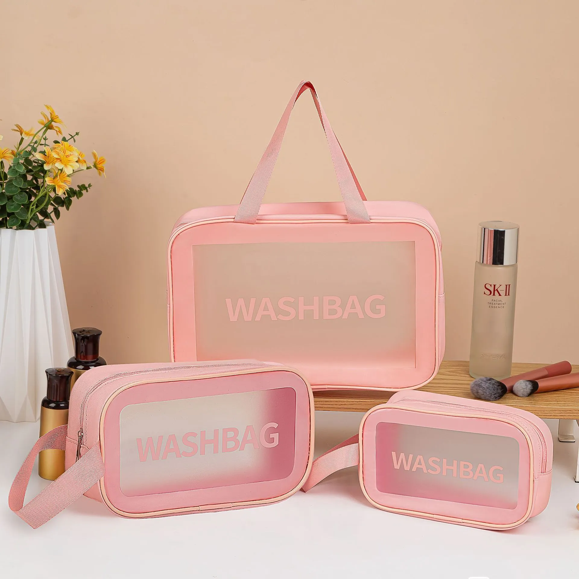 Large PVC transparent cosmetic bag three-piece set in various colours including beige, black, blue, pink, and white, empty and open on a flat surface
