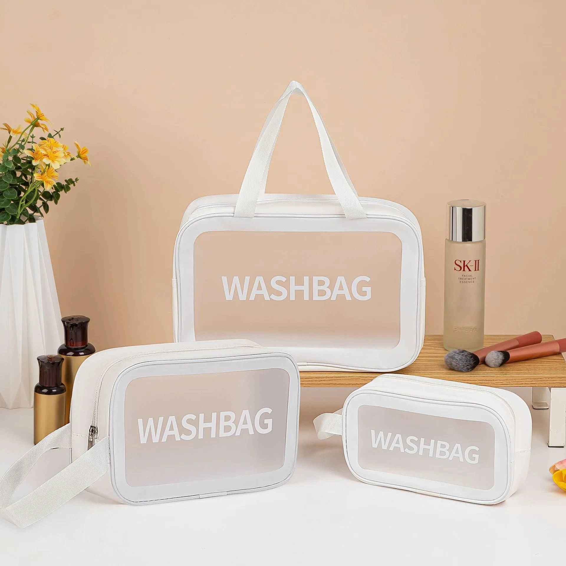 Large PVC transparent cosmetic bag three-piece set in various colours including beige, black, blue, pink, and white, empty and open on a flat surface