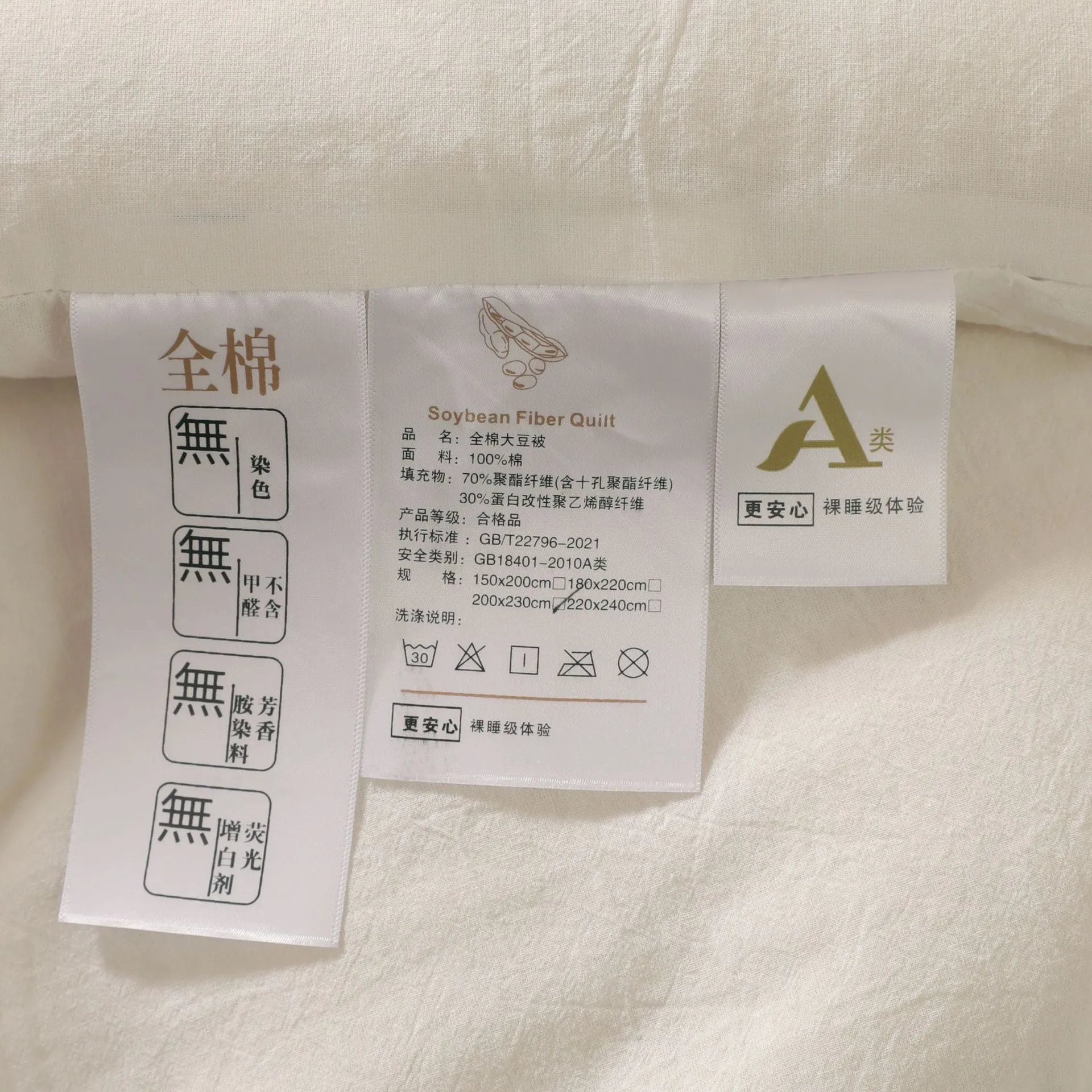 A pure cotton soybean fibre quilt in grey, shown folded, with details of its twill weave and size label.