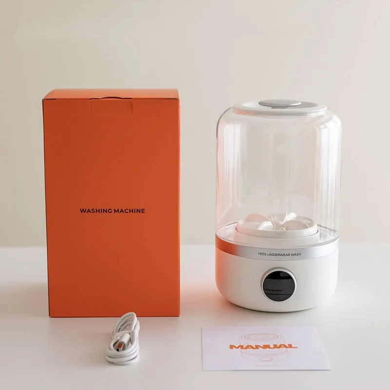 White portable laundry cup rechargeable small washing machine with charging cable on a table