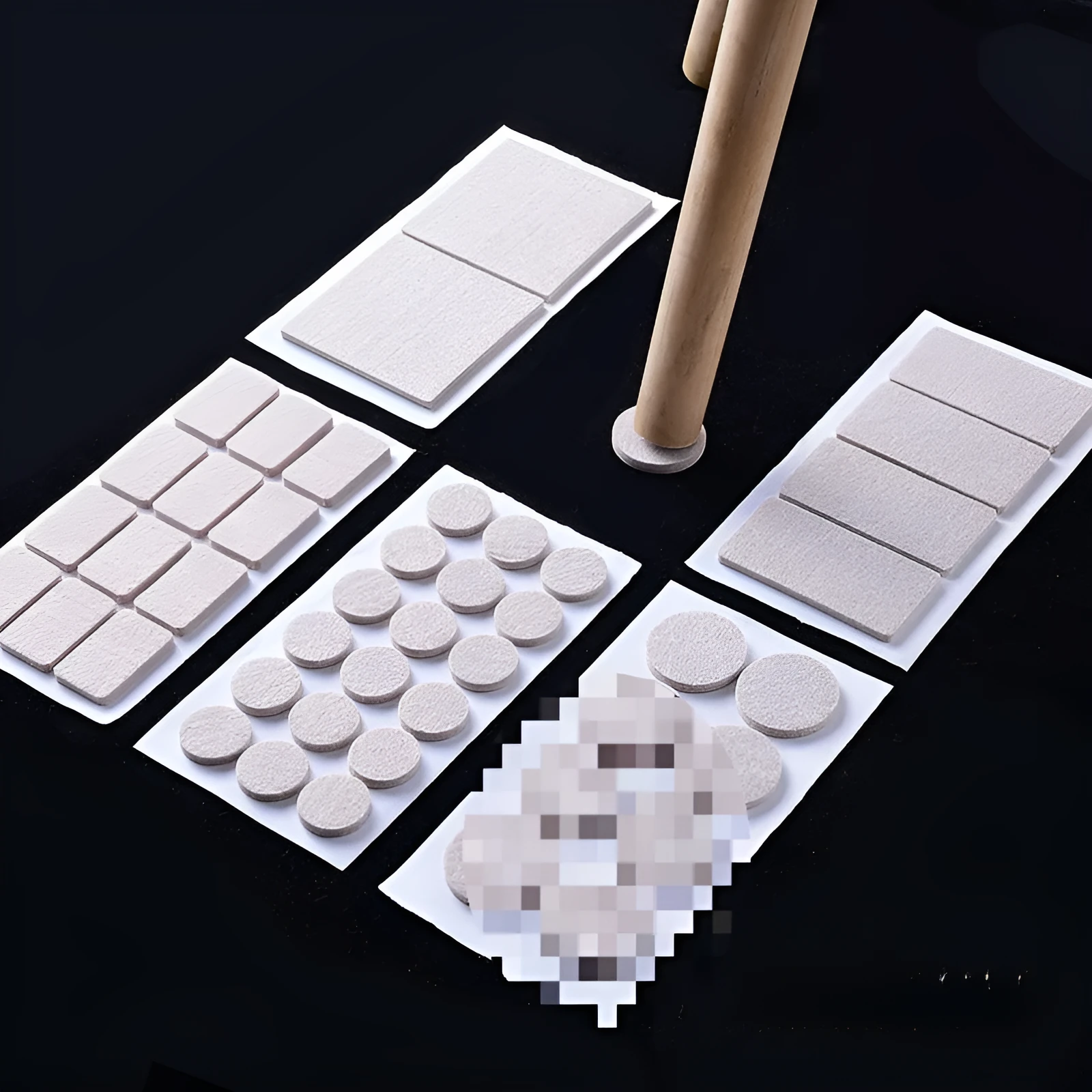 Beige plastic furniture protection foot pads in five different sizes on a wooden floor.