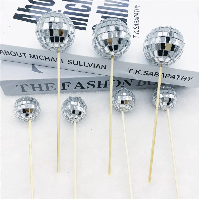 Glass mirrored disco ball cake decoration on a wooden stick, shown in different sizes.