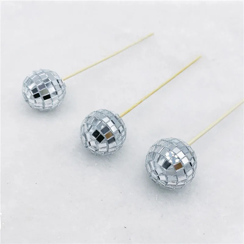 Glass mirrored disco ball cake decoration on a wooden stick, shown in different sizes.
