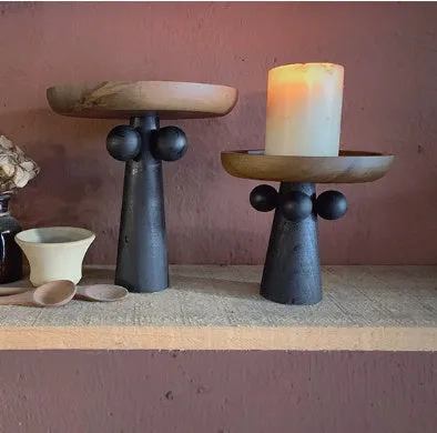 Nordic style round wooden tray with high legs for displaying candles and aromatherapy items.