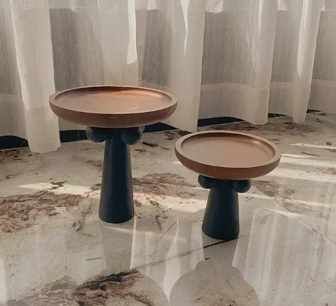 Nordic style round wooden tray with high legs for displaying candles and aromatherapy items.