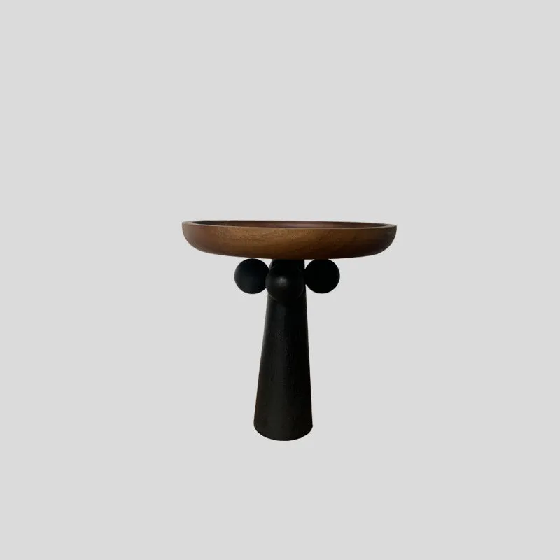 Nordic style round wooden tray with high legs for displaying candles and aromatherapy items.