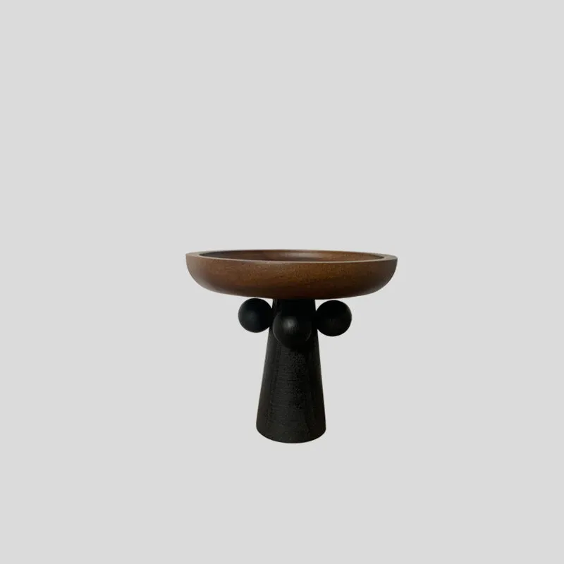Nordic style round wooden tray with high legs for displaying candles and aromatherapy items.