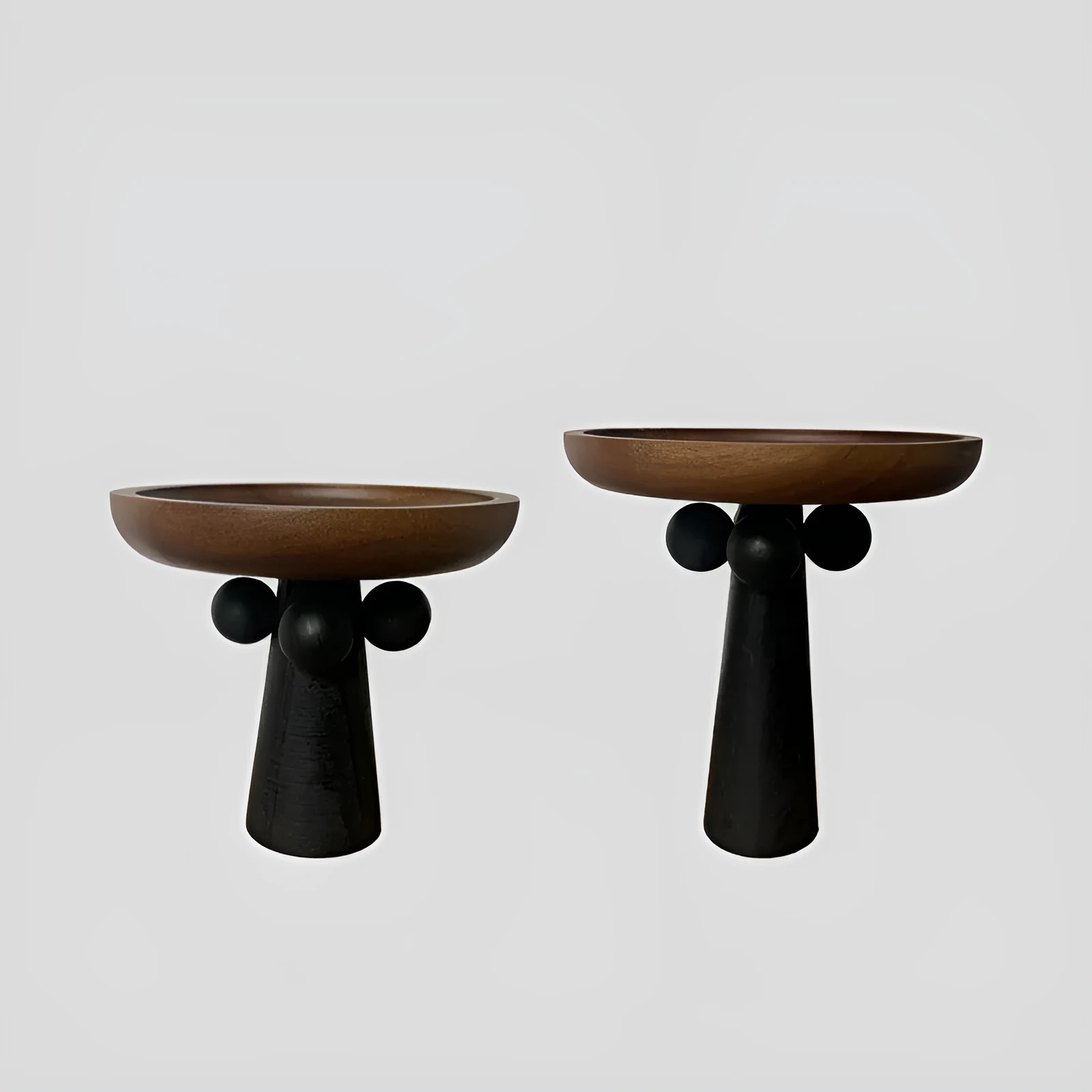 Nordic style round wooden tray with high legs for displaying candles and aromatherapy items.