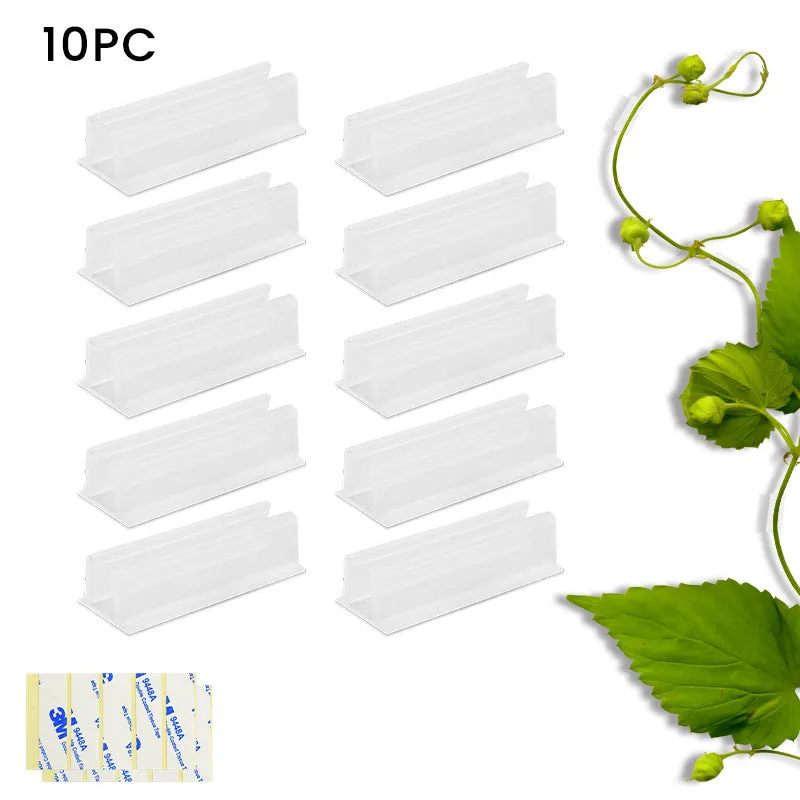 Set of sticky plastic wall-mounted brackets holding data cables on a white wall in a bedroom