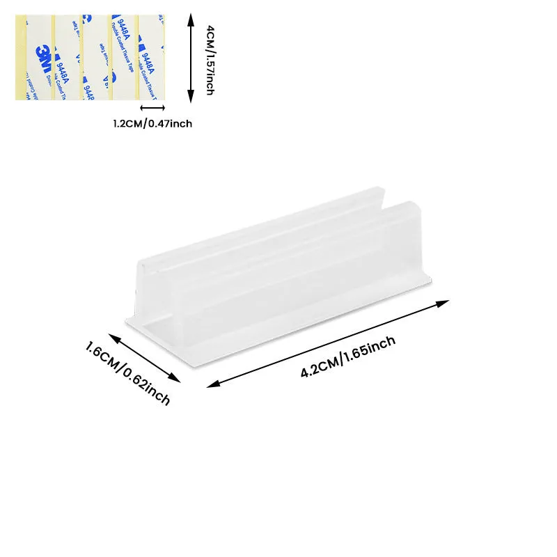 Set of sticky plastic wall-mounted brackets holding data cables on a white wall in a bedroom