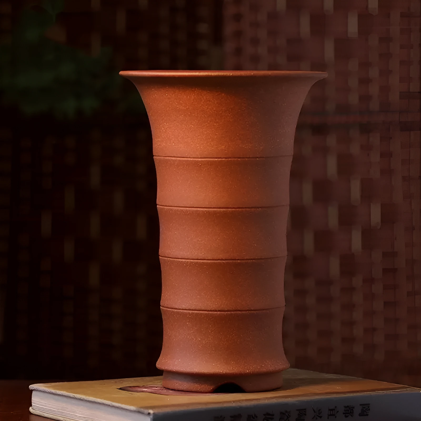 Boutique handmade descending slope ceramic orchid pot in mud purple sand on desktop