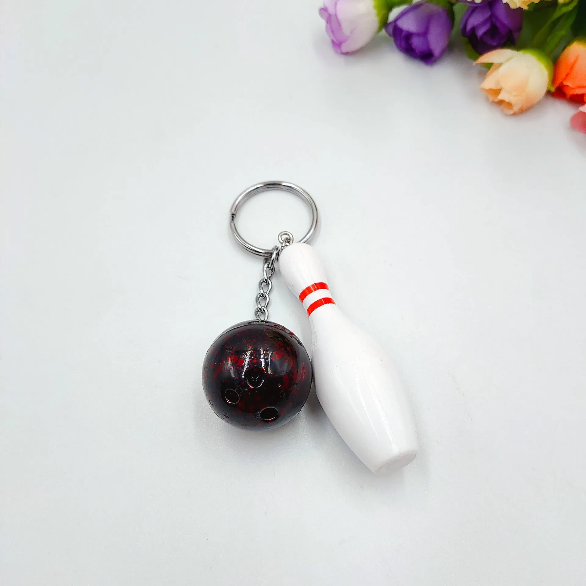Mini simulation sports bowling ball keychain pendant in dark red, blue, purple, and green colours.