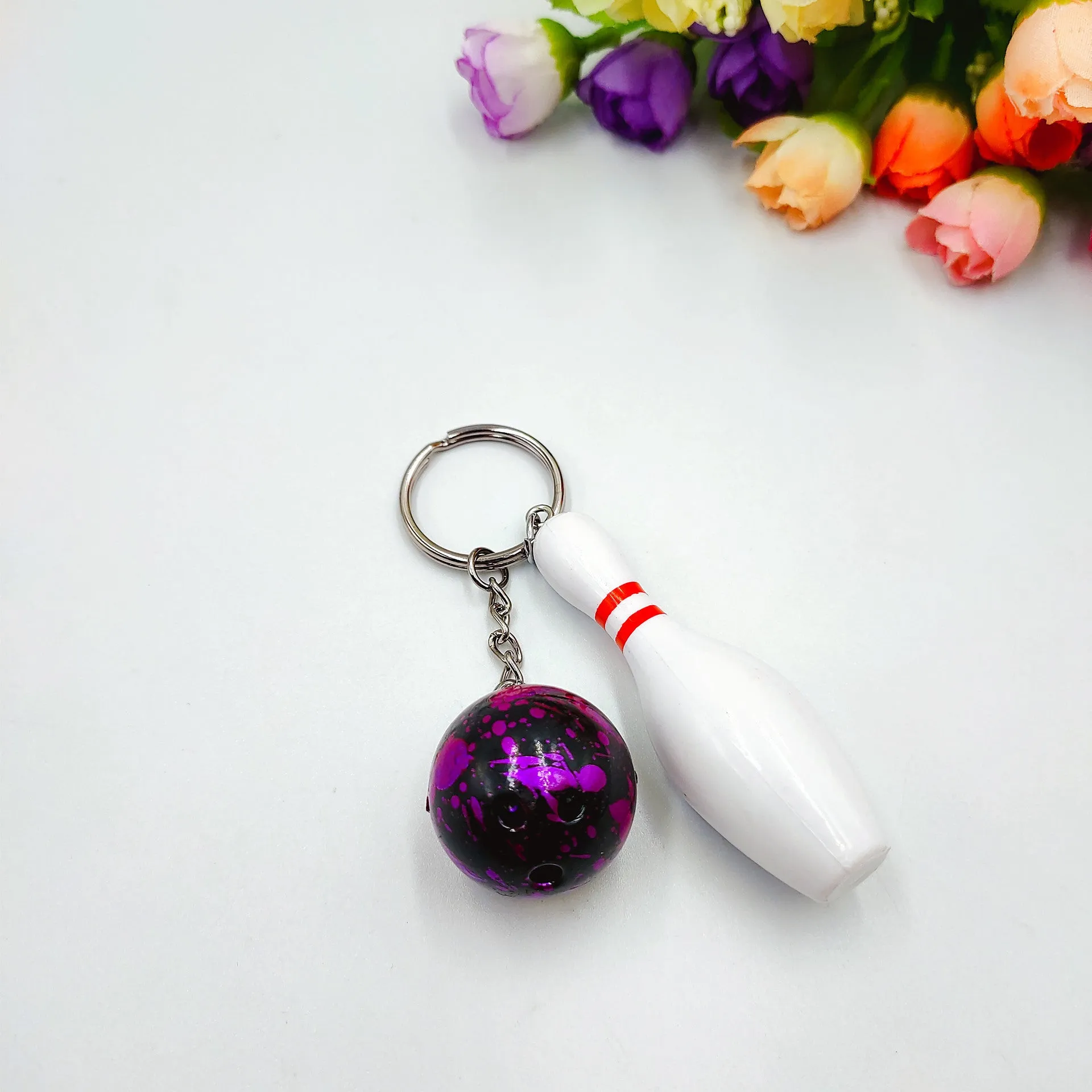 Mini simulation sports bowling ball keychain pendant in dark red, blue, purple, and green colours.