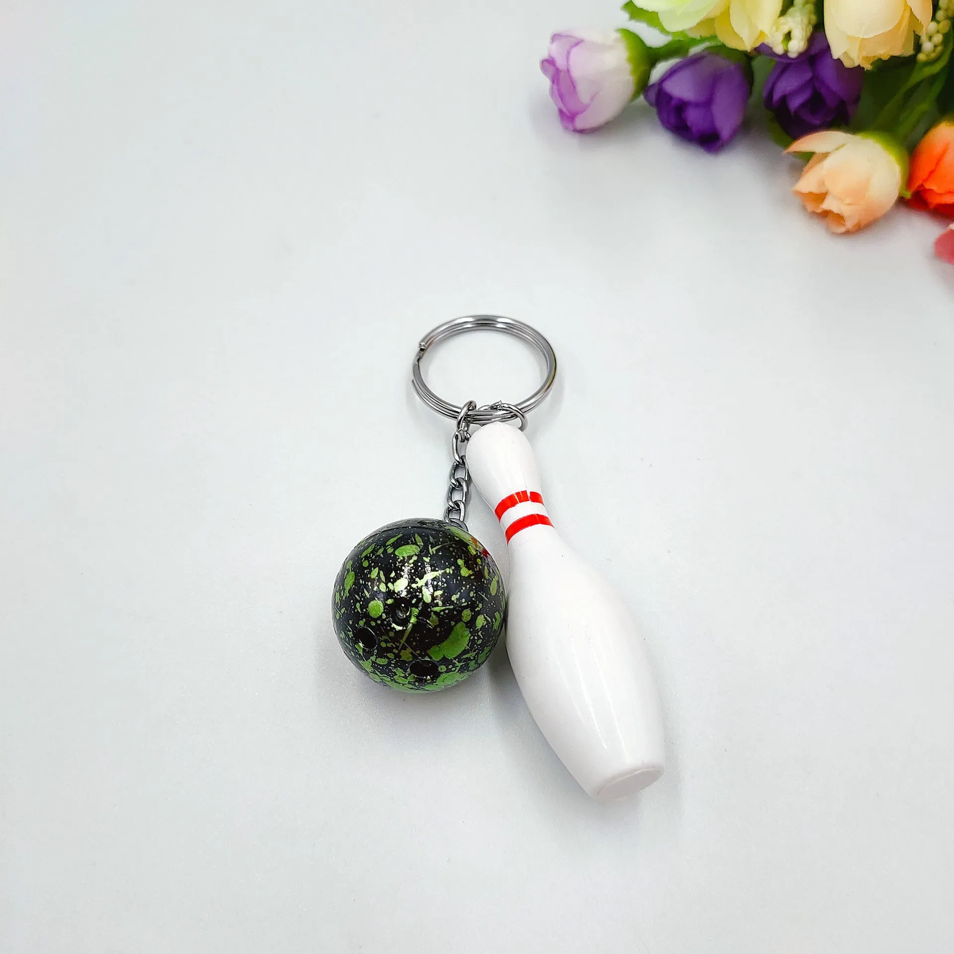 Mini simulation sports bowling ball keychain pendant in dark red, blue, purple, and green colours.