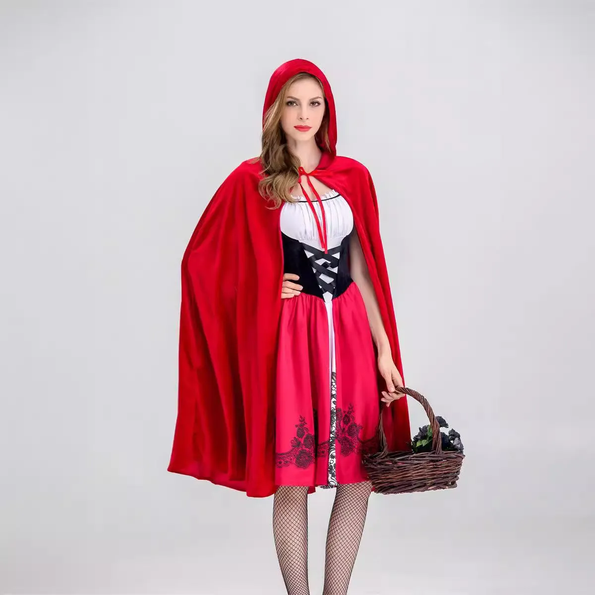Little Red Riding Hood costume set with dress, shawl, and gloves on a woman standing in a forest scene