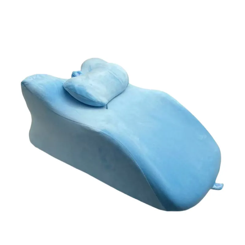 A prone position stomach sleeping pillow shown in a light grey colour, designed for use while reading in bed.