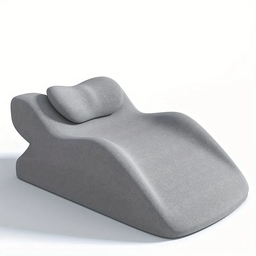 A prone position stomach sleeping pillow shown in a light grey colour, designed for use while reading in bed.