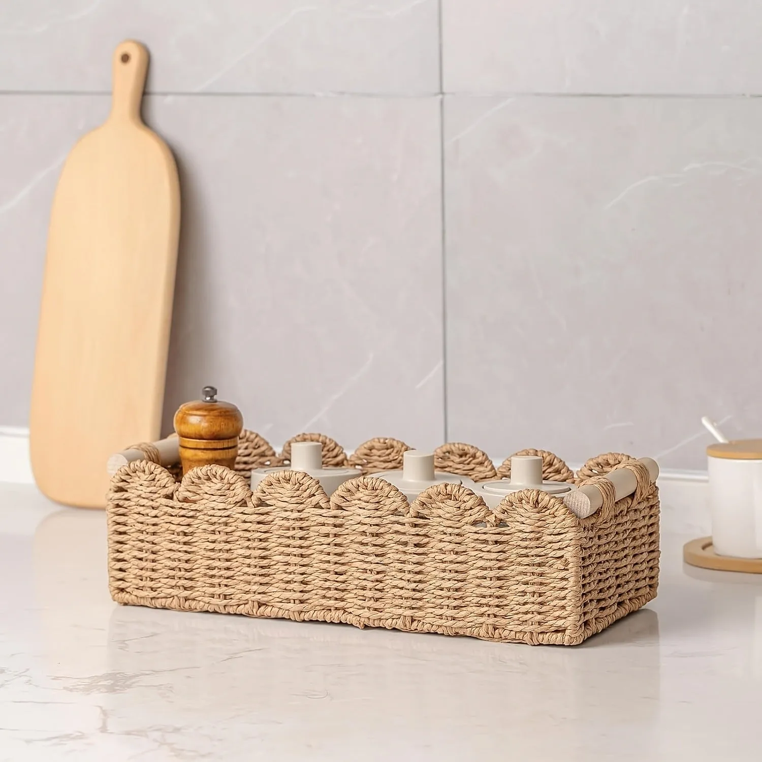 Rectangular woven paper storage basket in a neutral colour on a wooden tabletop.