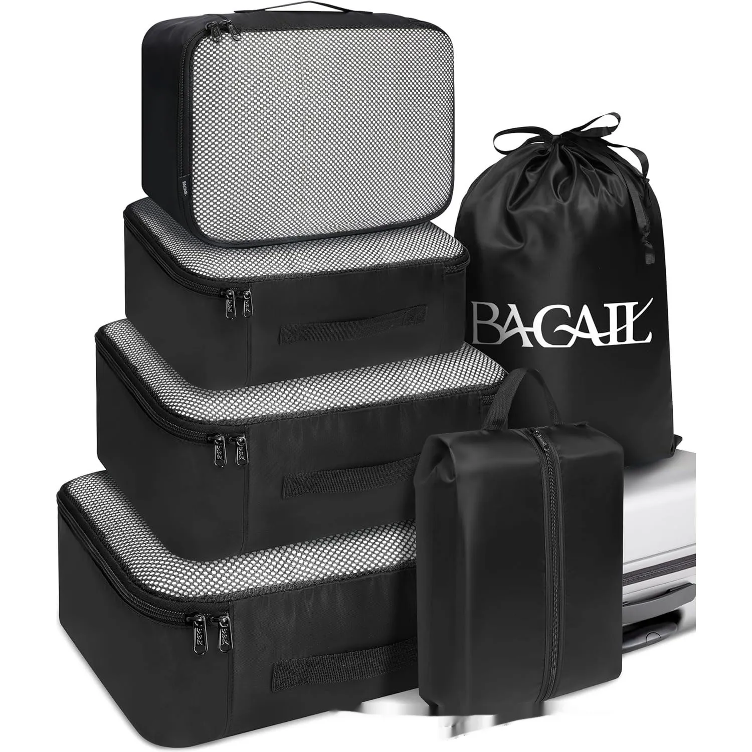 Set of eight cubic packing organisers in assorted solid colours including beige, black, and pink.