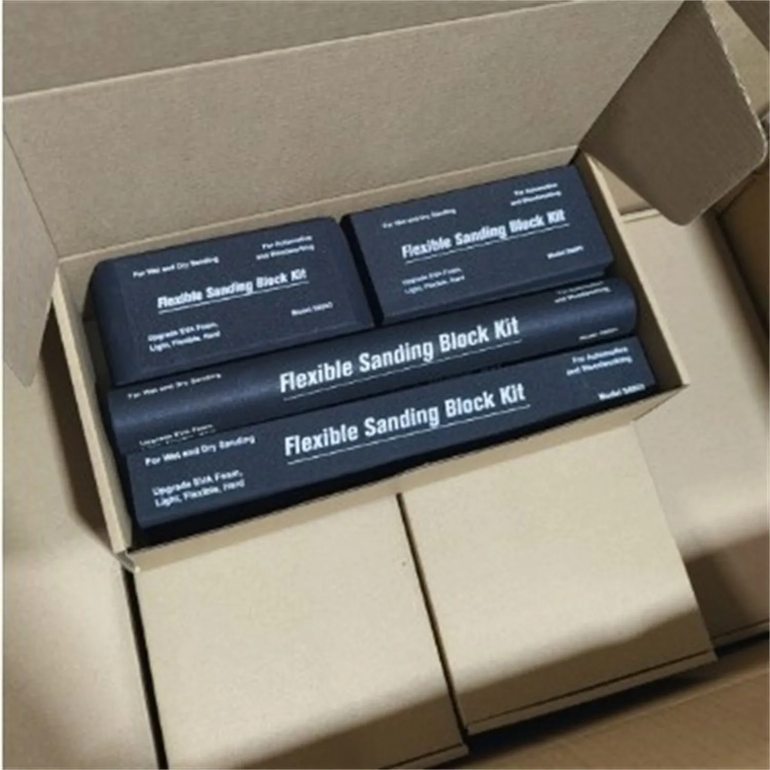 Seven black frosted metal building blocks arranged for architectural model assembly