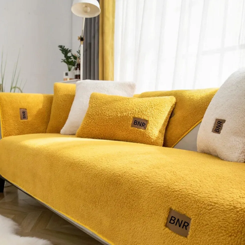 Solid colour lambswool sofa cover draped over a sofa, showing simple style and cloth liner.